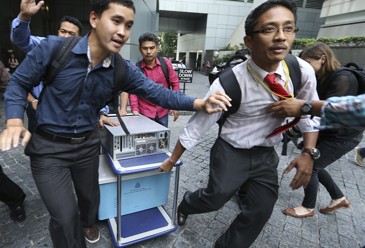 Members of the special task force investigating 1MDB with documents from the firm's office in July last year. The investigation was ordered to stop, raising concerns from Swiss authorities which recently discovered billions of dollars' worth of transfers involving Malaysian government companies. – The Malaysian Insider file pic, January 30, 2016.
