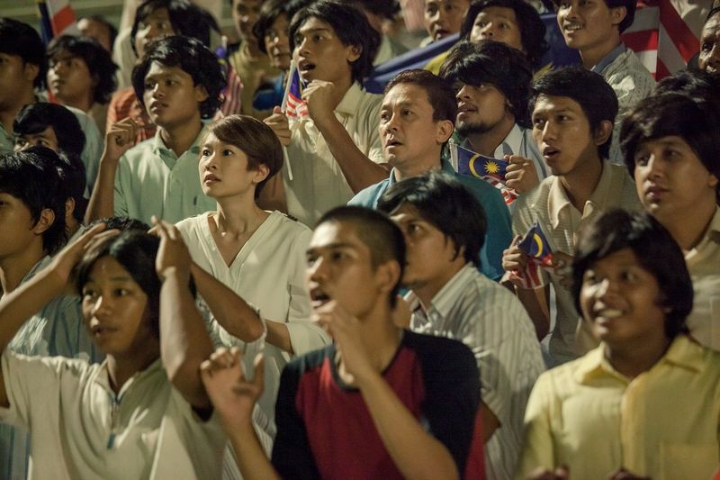 A good scene in the movie bringing the TV producer Marianne (centre, played by Marianne Tan) with the older version of the national legend Eric (Johnnie Lee), into the stadium as if they are witnessing him recalling the heroics of the national team live instead of just showing the latter relating the story in his living room. – Pic courtesy of Woohoo productions, January 28, 2016.
