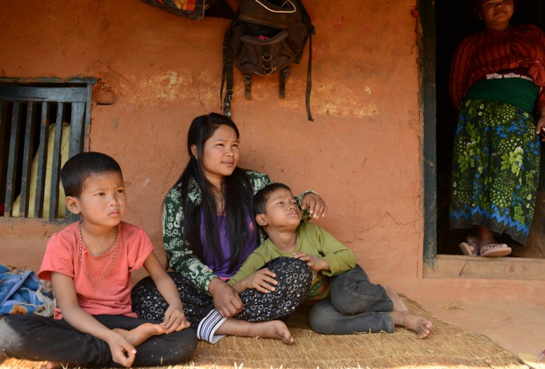 Nepalese migrant worker Sunita Magar (middle), who was trafficked to Syria, is back home with her mother (left), son Bipin Magar and daughter Elina Magar at their house in Dhadhing district, some 100km west of Kathmandu. Magar is among scores of poor Nepali and Bangladeshi women who travelled to the Middle East on the promise of a good job, only to be trafficked into Syria, wracked by five years of civil war. –  AFP pic, March 13, 2016. 