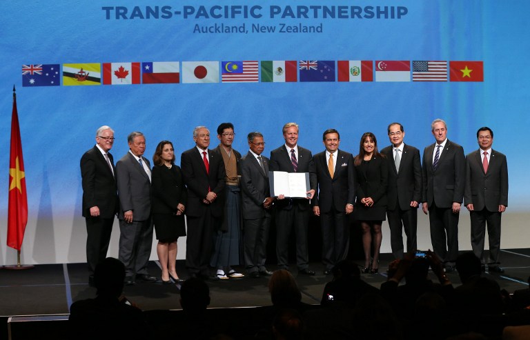 New Zealand Prime Minister John Key (centre) and ministerial representatives from 12 countries pose for a photo after signing the Trans-Pacific Partnership agreement in Auckland today. – AFP pic, February 4, 2016. 