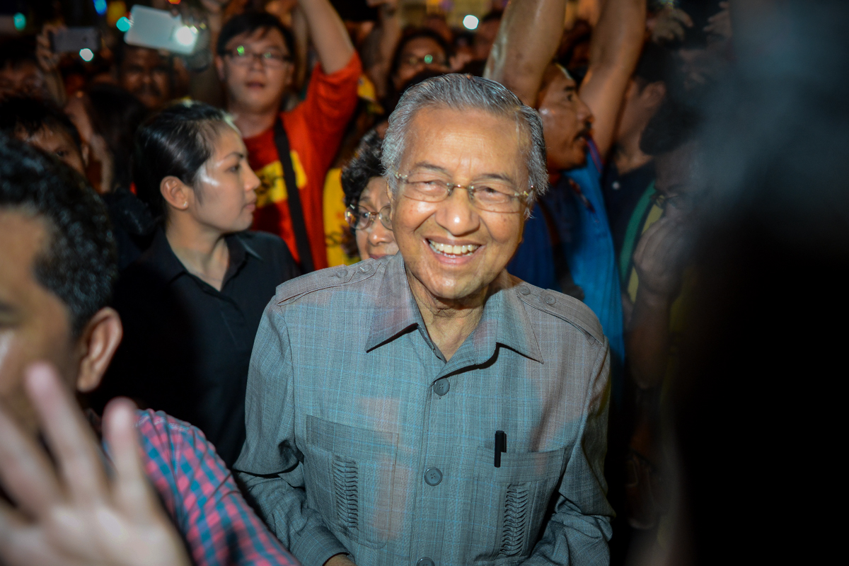 Tun Dr Mahathir Mohamad mobbed by the crowd as he makes a surprise appearance at the Bersih 4 rally last August. The former prime minister is expected to be questioned by police today. – The Malaysian Insider pic, November 6, 2015.